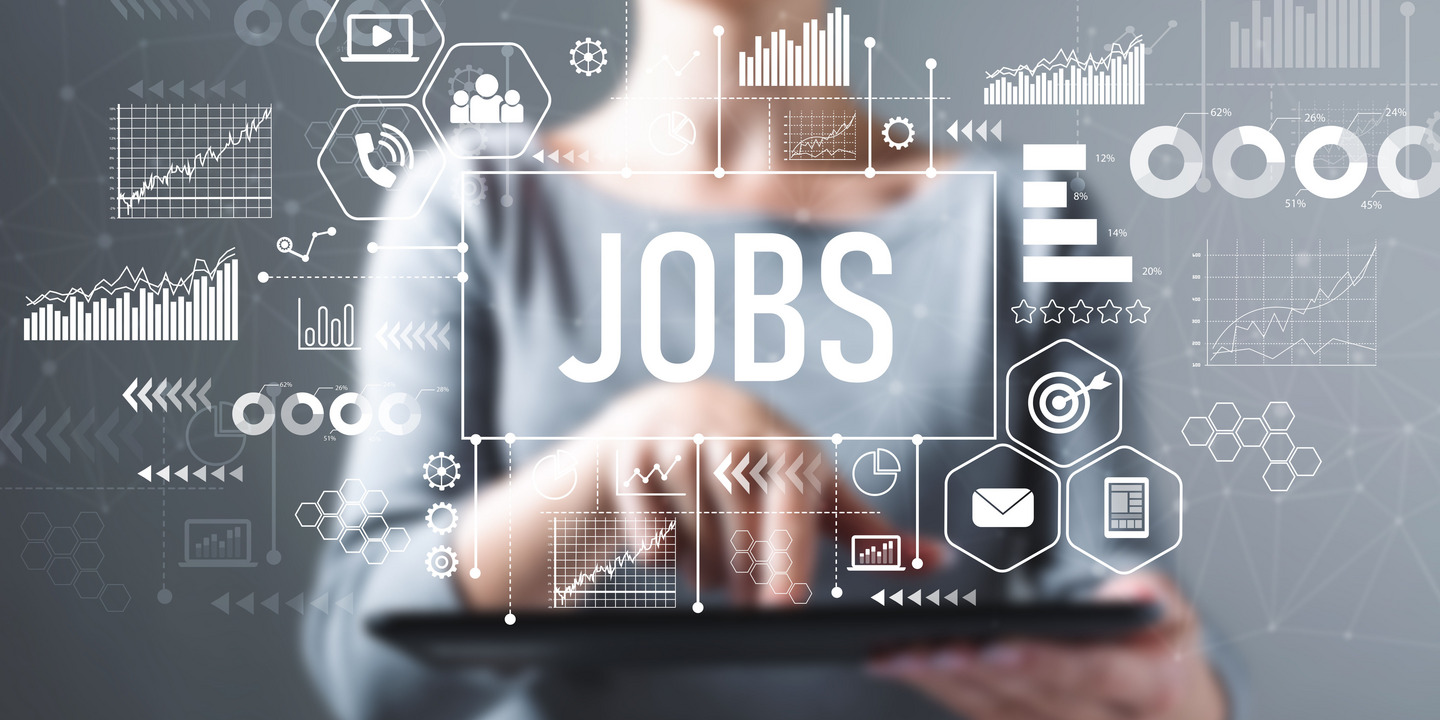 Graues Bild mit Frau im Mittelpunkt, deren Gesicht nur zur Hälfte zu sehen ist. Vor ihr sind Begriffe wie Jobs etc. wie auf eine scheinbar transparente Fläche geschrieben. Sie hält ein Tablet und deutet mit dem rechten Zeigefinger darauf.